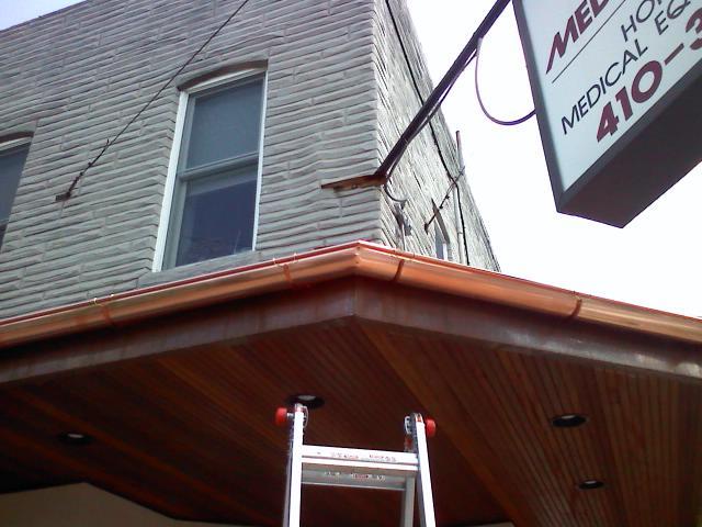 Copper half-round gutters installed on a Maryland business by The Gutter Guys